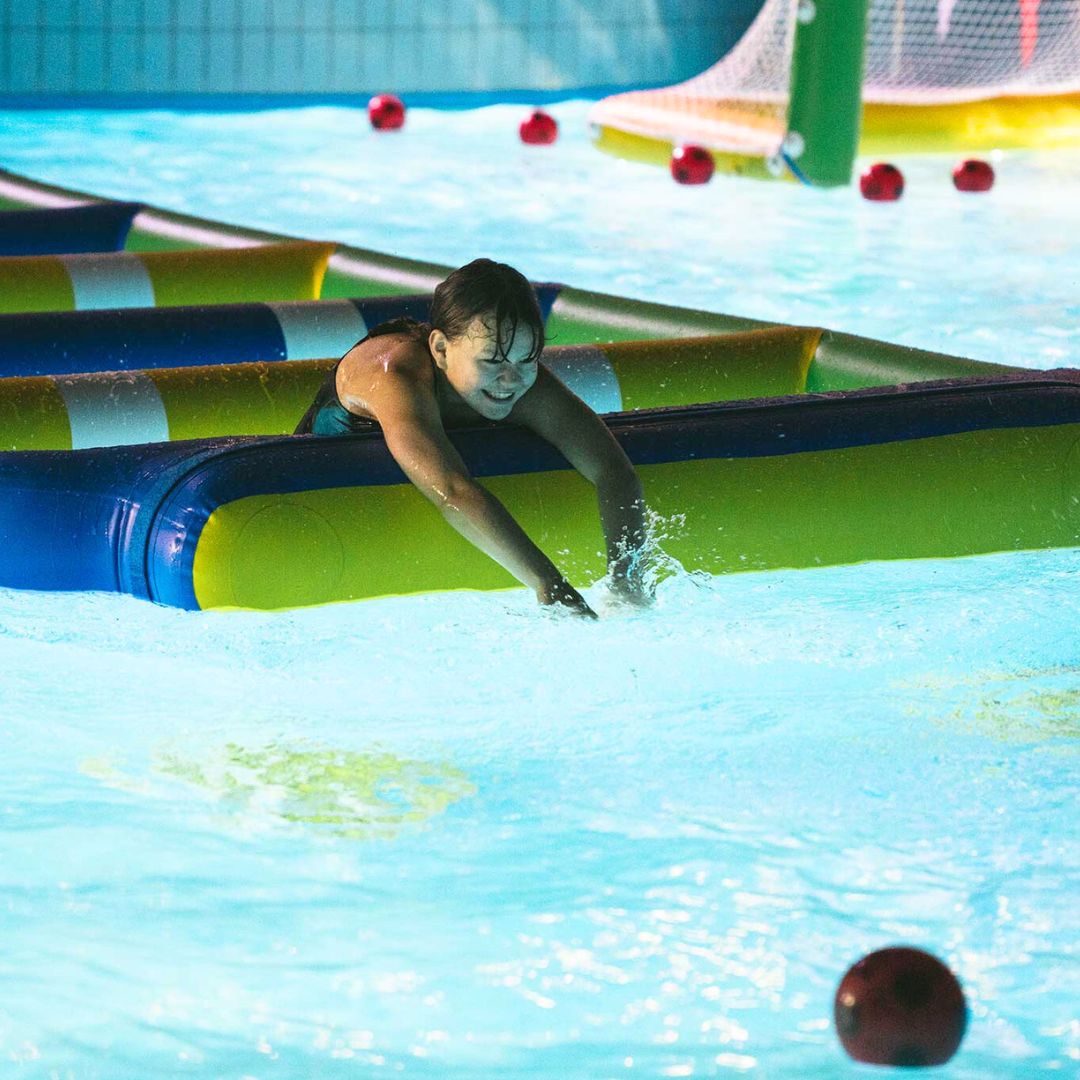 Lapsi kurkottaa palloa Flamingon Vesipuistossa.